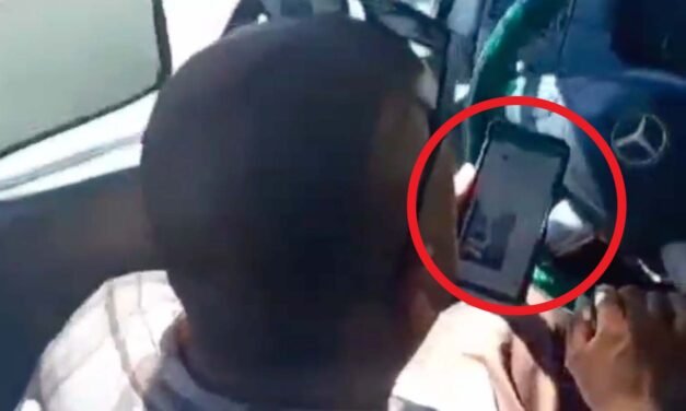 CHÓFER AL VOLANTE Y VIENDO SU CELULAR